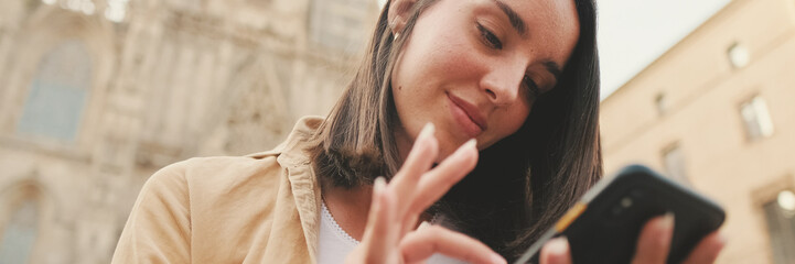 Close up, beautiful traveler girl using looking mobile phone sitting on the steps of an old...
