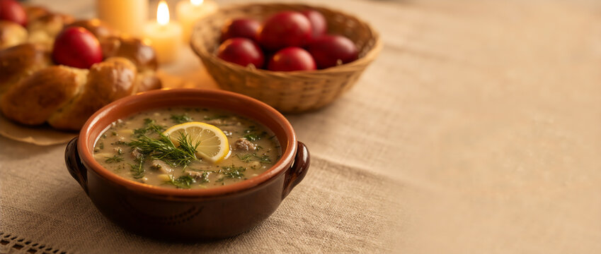 Traditional Greek Easter soup Magiritsa with lemon and dill. Festive table with red eggs, tsoureki bread and candles. Greek Orthodox holiday meal