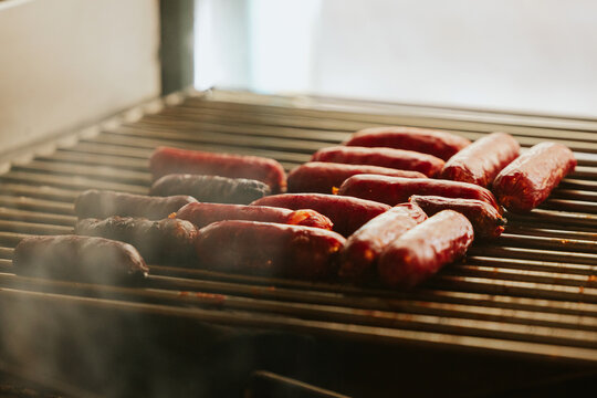 Grilled sausages on barbecue grill with smoky aroma