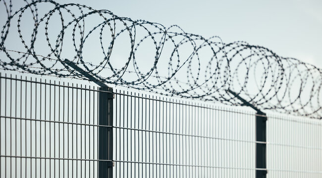 Barbed wire fence with clear blue sky