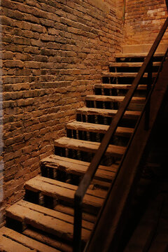 Rustic wooden staircase by an exposed brick wall
