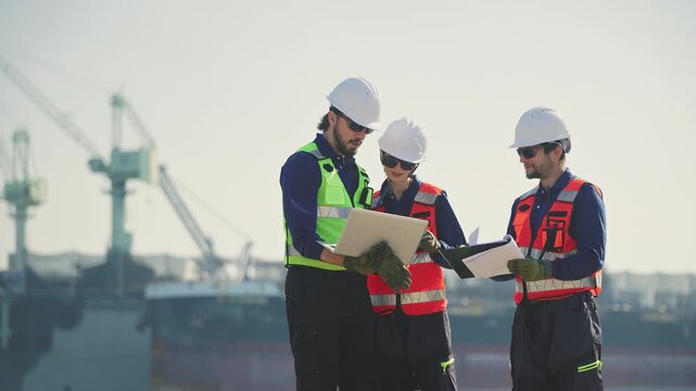 Engineering working at shipyard, Professional logistics monitoring cargo operations at industrial shipyard, transportation, harbor, infrastructure, distribution, freight, commercial shipping.