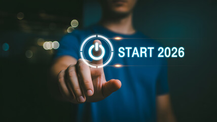 Fototapeta premium Man Pressing Digital Power Button with Start 2026 Text Overlay Representing New Year Goals and Future Business Launch