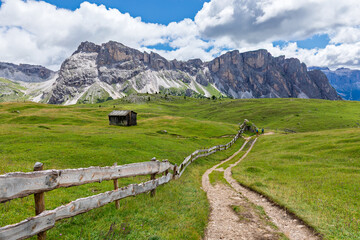 Mountain path and old barn in Alpine meadow, Dolomites, Italy