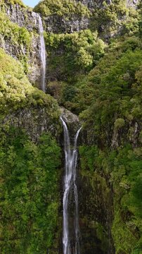Stunning aerial perspective of Cascata do Risco waterfall in Madeira, surrounded by lush green cliffs and cascading into a serene pool below, highlighting the island's natural beauty