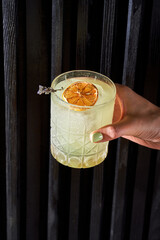 Refreshing orange citrus cocktail in a crystal rocks glass on a dark background