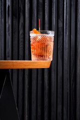 Refreshing orange citrus cocktail in a crystal rocks glass on a dark background