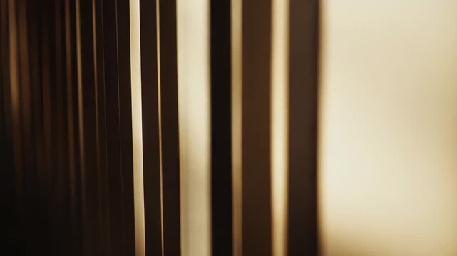 Warm sunlight streaming through window blinds creating strong vertical patterns of light and shadow across a textured surface, evoking feelings of calm and natural beauty