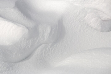 Close up of textured curves on fresh white powder snow background