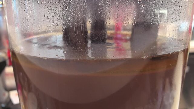 Warm steam rises from a rich cup of hot chocolate, showcasing creamy layers. Close-ups reveal the inviting texture and color, perfect for a chilly day in a charming cafe.
