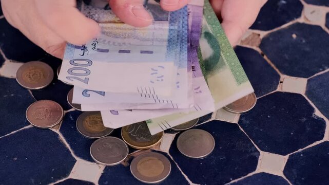 closeup Moroccan dirham money, coins on traditional table, count paper dirham banknotes, cash payments, monetary savings, save for vacation, exchange and cashing currency