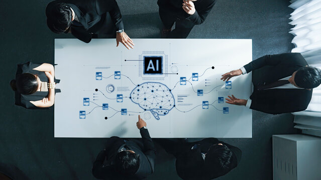A diverse team of professionals engages in a strategic discussion on artificial intelligence, analyzing a digital brain diagram on a sleek conference table. Trope