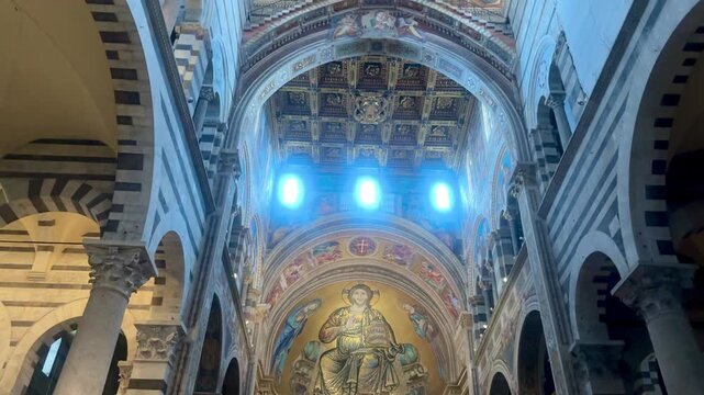The interior of Pisa Cathedral is spacious and bright, with a central nave flanked by marble columns and arches in the Pisan Romanesque style. 