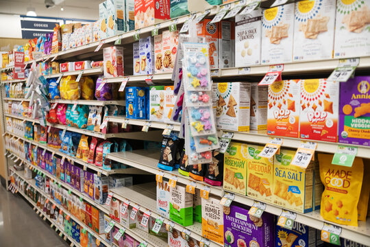 Grocery store snack aisle with crackers cookies and packaged food on shelves