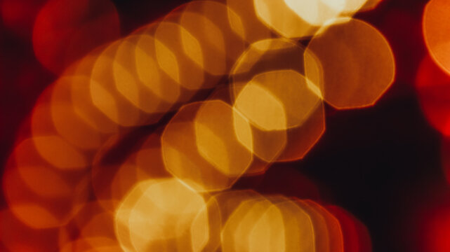 Golden yellow bokeh lights with blurred octagonal shapes on a dark background.