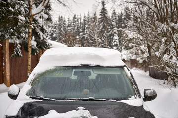 Person clearing deep snow with a shovel near a car in winter. Everyday winter routine, cold weather conditions, hard work and seasonal challenge. Real life outdoor scene with copy space