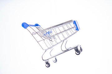 A shopping cart is suspended in midair. The cart is silver and blue. The cart is not on the ground