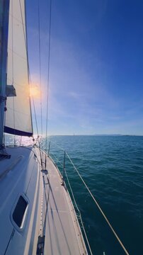 Valencia sailboat at sunset cruising on Mediterranean sea with golden light