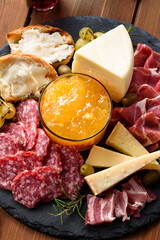 Piatto con prosciutto crudo, salame, guanciale, crostini con crema di formaggio, parmigiano, pecorino, frutta secca e frutta fresca  - Antipasti Italiani 