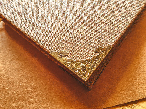 Old vintage brown book with decorative gold metal corner