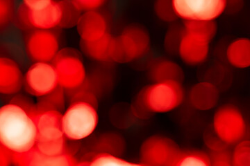 Fototapeta premium a mesmerizing pattern of blurred red bokeh lights ranging from deep crimson to bright glowing circles.