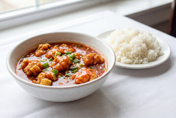 Savory Shrimp Delight: A culinary close-up features a bowl of succulent shrimp bathed in a rich, flavorful sauce alongside a serving of fluffy, white rice, promising a delightful dining experience.