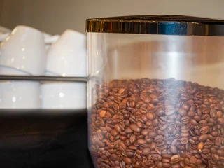 Selbstklebende Fototapeten Kaffeebohnen Grains de café dans un moulin professionnel lors d’une pause café en entreprise, espace de restauration lors d’un événement intérieur  © Colombe Delons