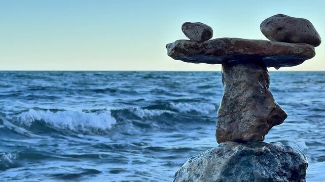 Business resilience symbolized by balanced stones on ocean shore