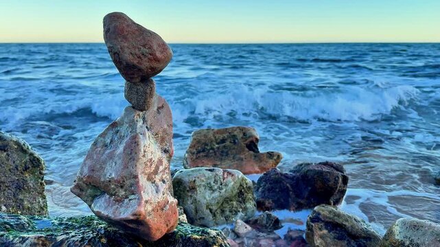 Risk management metaphor with balanced stones against sea waves