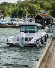 Fototapeta premium Gothenburg, Sweden - June 29 2025: Modern motorboat docked beside wooden pier.