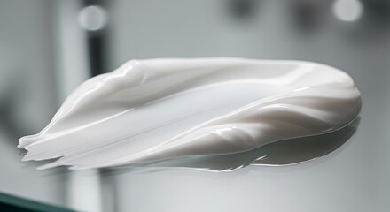 Luxurious white cosmetic cream smear on a reflective surface, showcasing smooth texture and elegant sheen. Ideal for beauty, skincare, and spa product promotions.