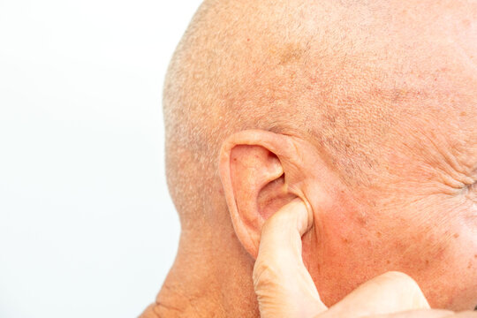 man touches ear canal, suggesting discomfort from earwax buildup or hearing issues, Signs of blocked ears, ossibly experiencing hearing loss or pressure, health concern, self-care procedure