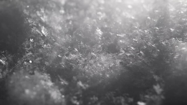 Macro video of permafrost snow in extreme cold tones. For a few seconds, light appears and ice crystals begin to sparkle and refract, creating a dramatic frozen atmosphere.