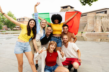 Italian community smiling together with national flag. Diverse young people sharing pride and...