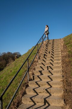 lady standing on top of stairs in uins of medieval Dutch hilltop Castle Valkenburg aan de Geul, Limburg, Netherlands. Historic landmark monument popular tourist educational attraction for sightseeing