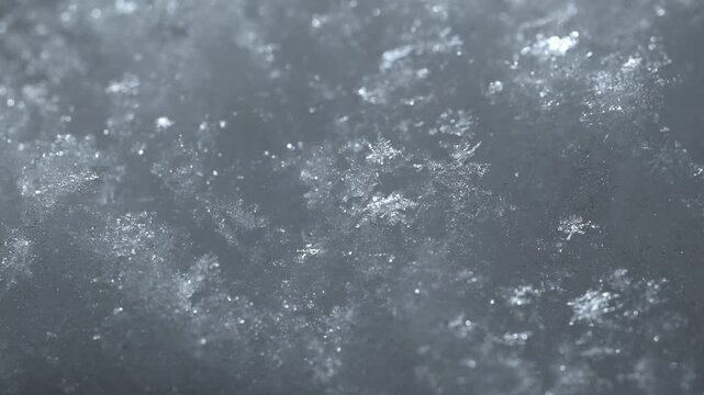Macro video of light flares shimmering on fresh snow. Sparkling highlights and crystalline textures reflect light, creating a clean winter atmosphere ideal for cinematic and abstract visuals.