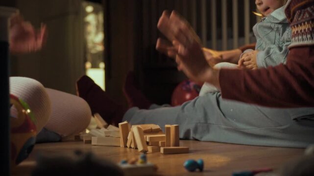Young family plays Jenga together on cozy evening at home, fostering bonding development. father, mother, and little daughter collaborate, enjoying warm atmosphere that nurtures their childs growth