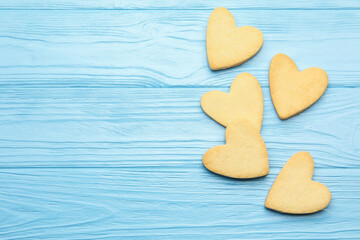 Obraz premium Delicious heart shaped butter cookies on light blue wooden table, flat lay. Space for text
