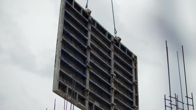Metal formwork lifted by crane at construction site
