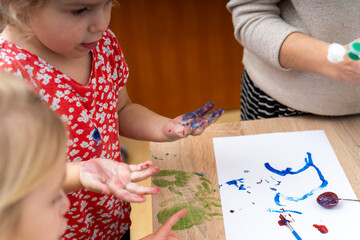 Children enjoy painting at a craft activity in a classroom during the afternoon on a sunny day