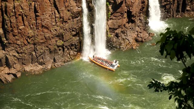 Speed boat rides under Iguazu Falls in Argentina - Brasil Border is one of the Natural Seven Wonders of the World and an UNESCO World Heritage Site. High quality 4k footage