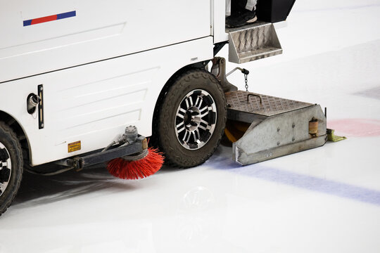 close-up view of an ice resurfacing machine, commonly known as a Zamboni, in operation on an ice rink