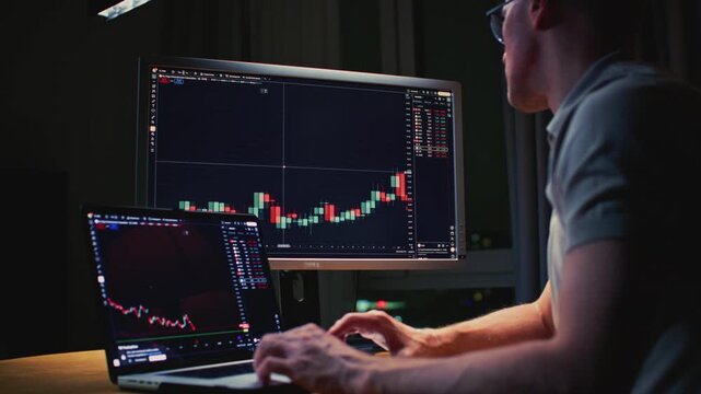 Unrecognizable man stock trader in home office. Male analyzes terminal, trades stocks on crypto market. Quotes from Bitcoin Ethereum. Candlestick or trading charts, price action on the laptop screen