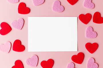 Valentines day card mockup. Empty greeting card flat lay with stylish pink and red hearts on pink paper background. Happy Valentine's day postcard with space for text
