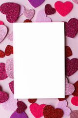 Happy Valentine's day greeting card! Empty card with space for text and stylish pink and red hearts flat lay on pink paper background. Modern love postcard mockup