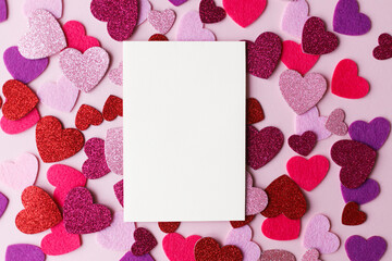 Valentines day card mockup. Empty greeting card flat lay with stylish pink and red glitter hearts on pink paper background. Happy Valentine's day postcard with space for text