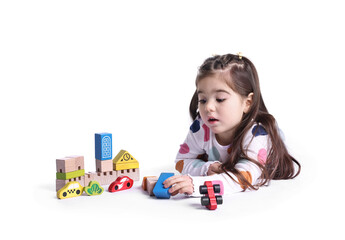 Cute little girl playing with toys on white background