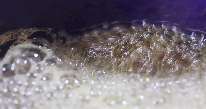 Melted sugar dissolved in water boiling, making syrup for oriental cakes like baklava