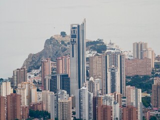 Obraz premium City skyline scene, Highrise building with rugged mountain background and surrounding structures