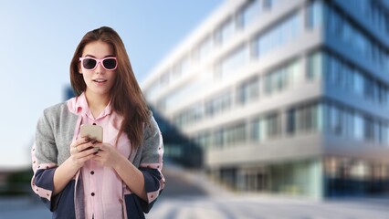 Obraz premium pretty young woman walking city street hold phone
